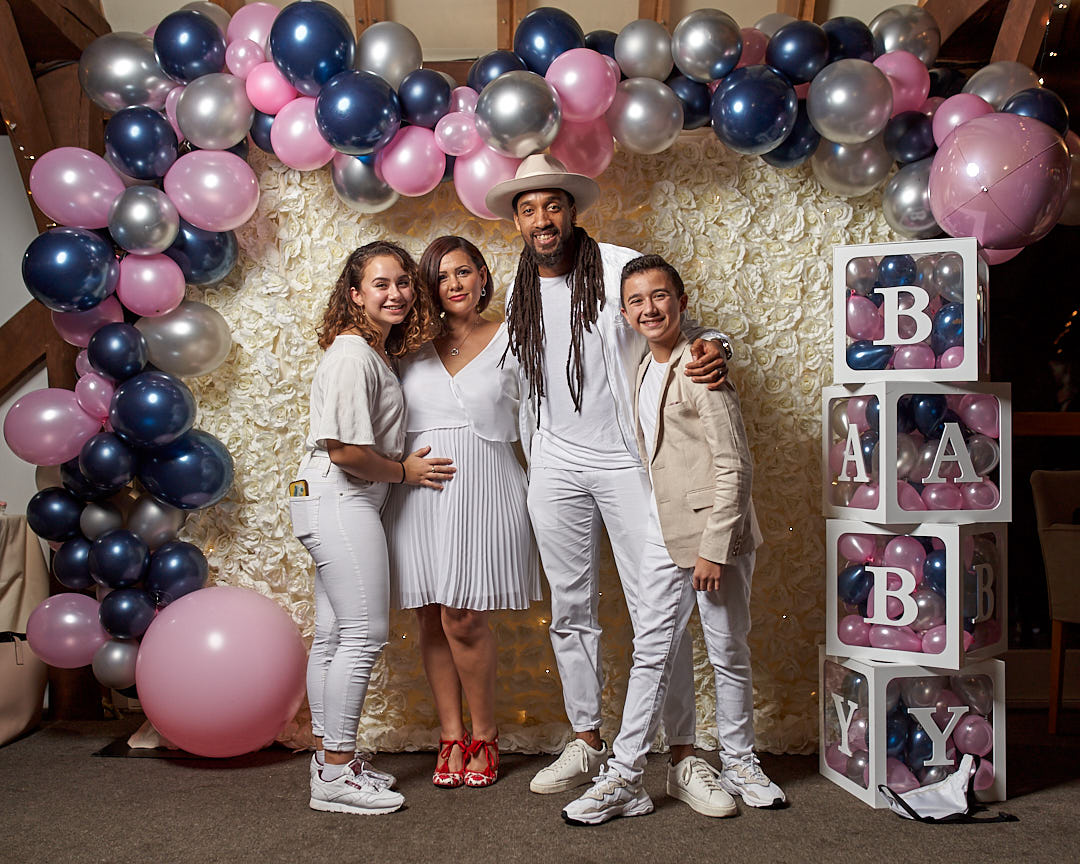 A group of family posing for a family portrait in a baby shower event