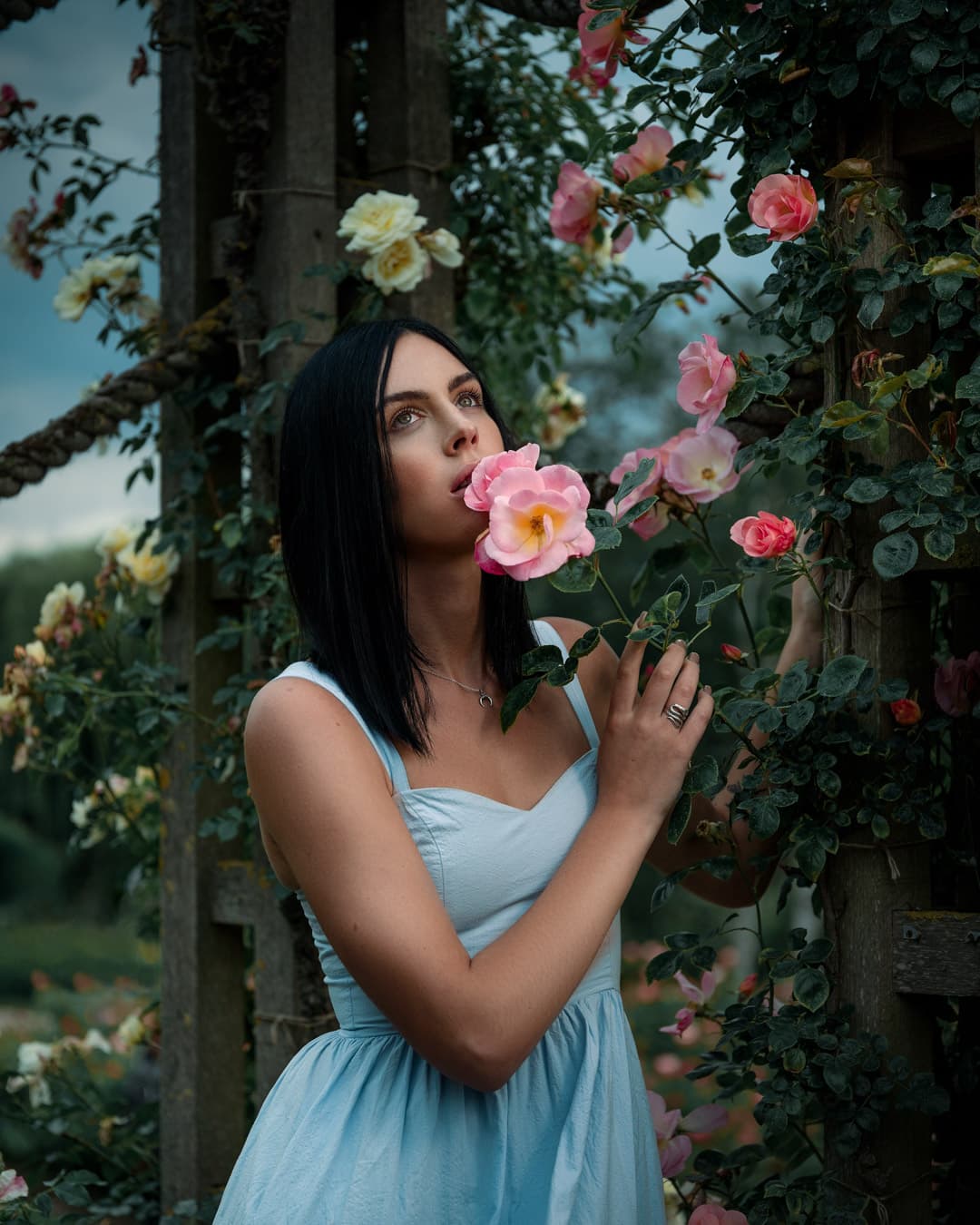 A woman in blue dress surrounded by orchids