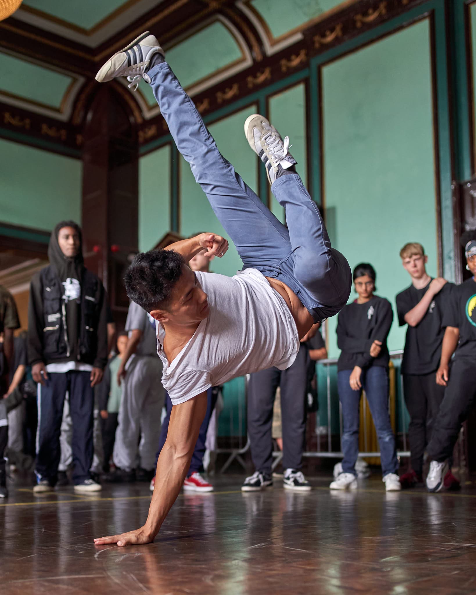 A man doing a hand stand and crowd looking at him